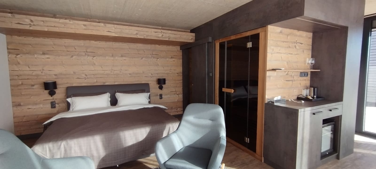Ložnice a kuchyň v apartmánu JBX Resort Apartments Lipno se vstupem do soukromé sauny.