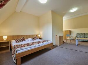 Dvoulůžkový pokoj s manželskou postelí a přistýlkou (východní část budovy, druhé patro)